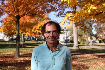 Headshot of Dr. Douglas Munoz, outside in front of trees with orange leaves