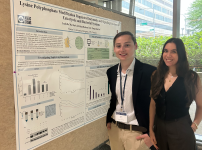 Isabella Martins and Ethan Belrose stand to the right of their research poster.